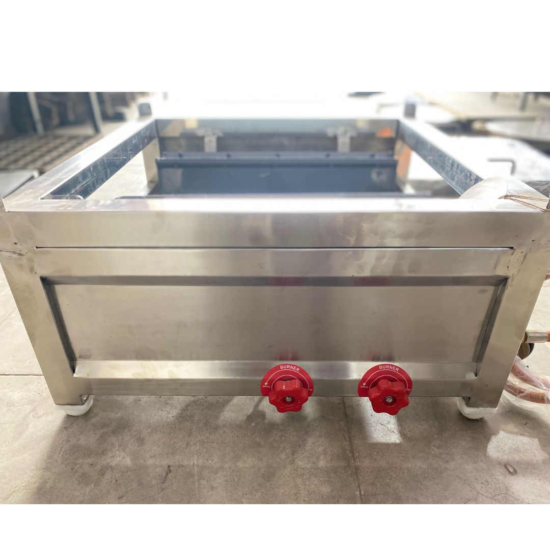 Stainless steel machine with red handles on a concrete floor