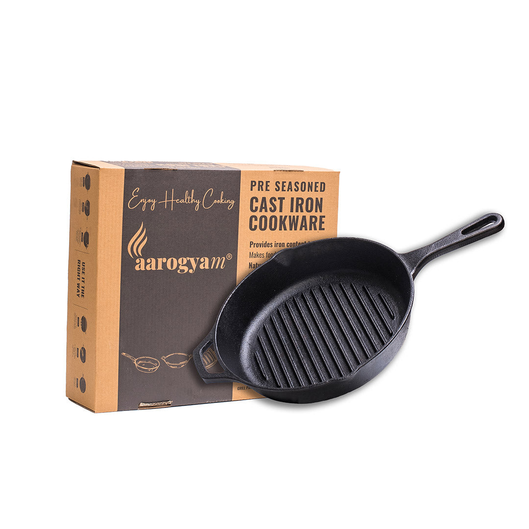 Black cast iron skillet with grill pattern next to aarogyam branded packaging on a white background