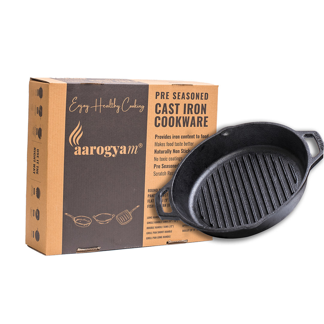 Cast iron skillet next to its packaging box with 'aarogyam' branding.
