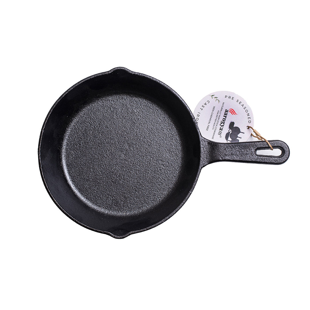 Black cast iron skillet with a handle on a white background