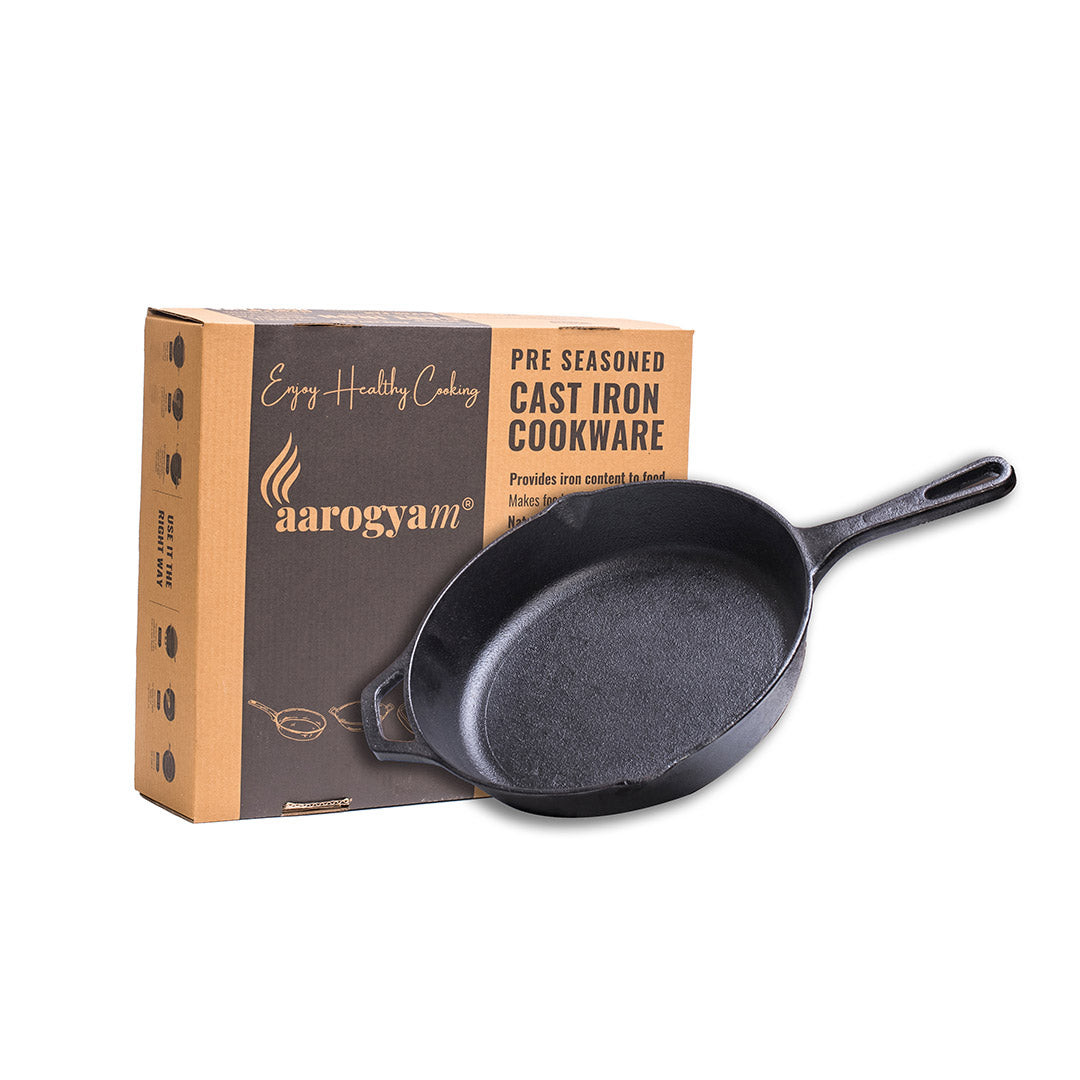 Cast iron skillet with aarogyam packaging on a white background