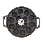 Cast iron pan with multiple round depressions on a white background