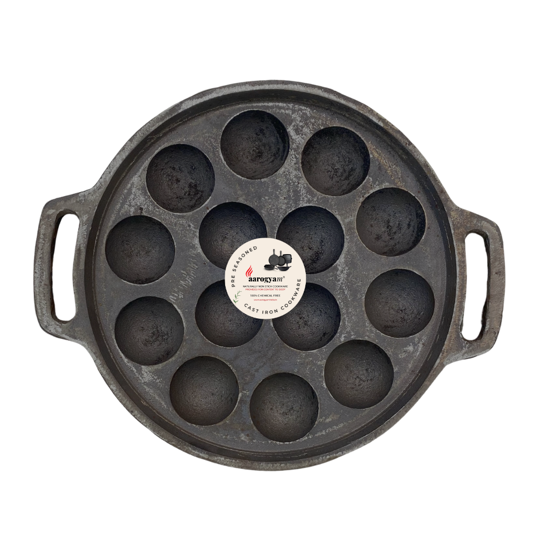 Cast iron pan with multiple round depressions on a white background