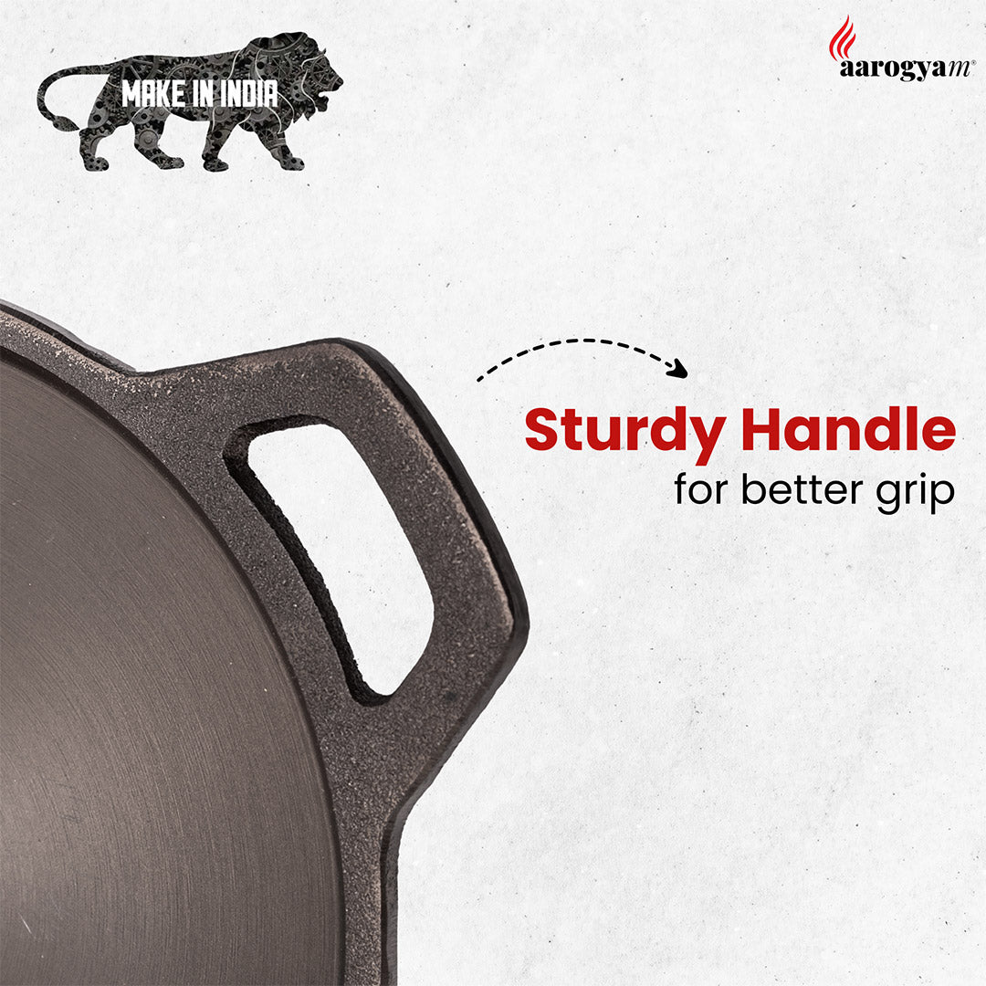 Close-up of a cast iron skillet with a sturdy handle, featuring 'Make in India' and 'aarogyam' logos.