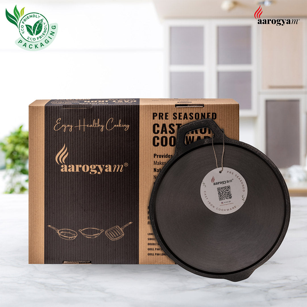 Aarogyam pre-seasoned cast iron cookware with packaging in a kitchen setting