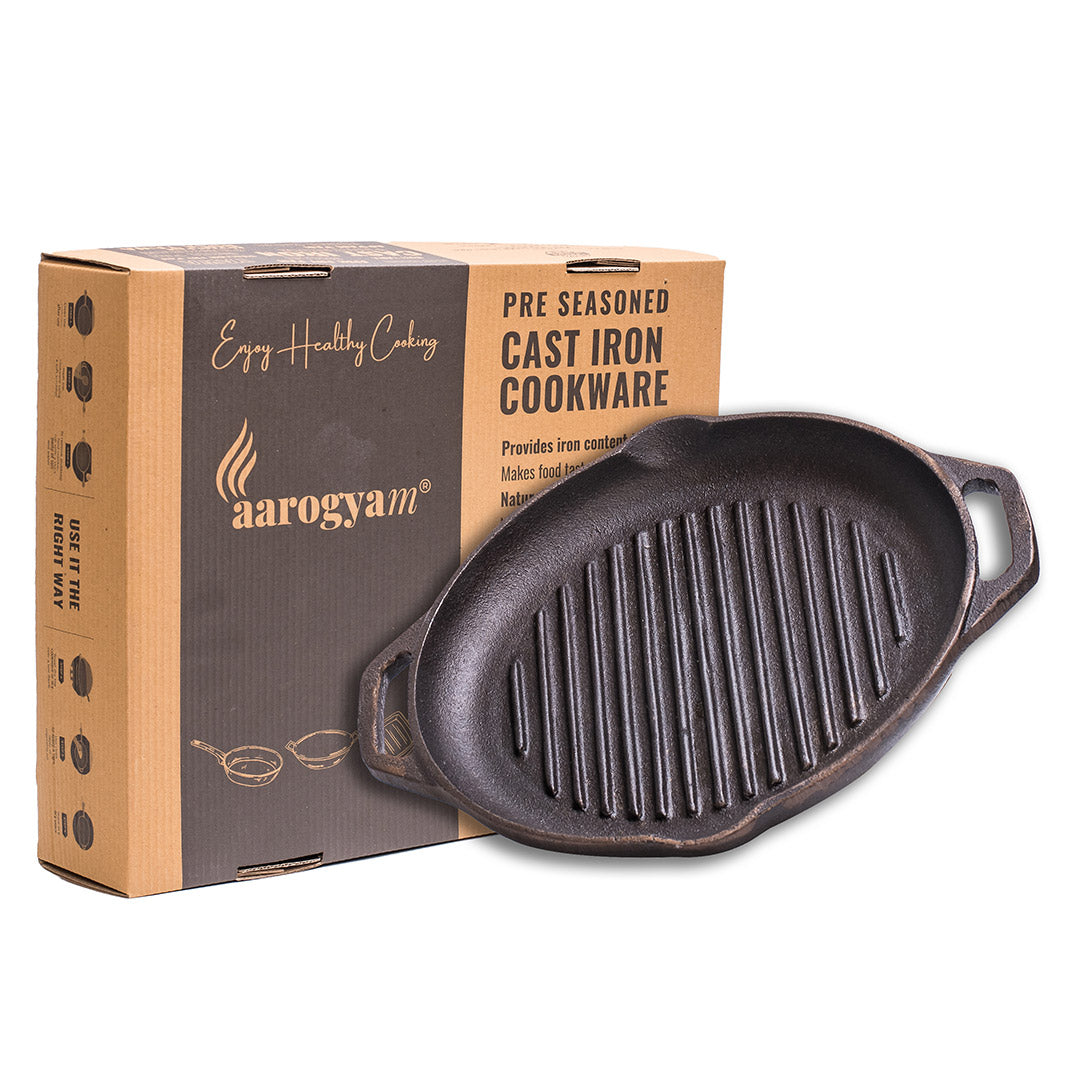 Cast iron skillet with Aarogyam branded packaging on a white background