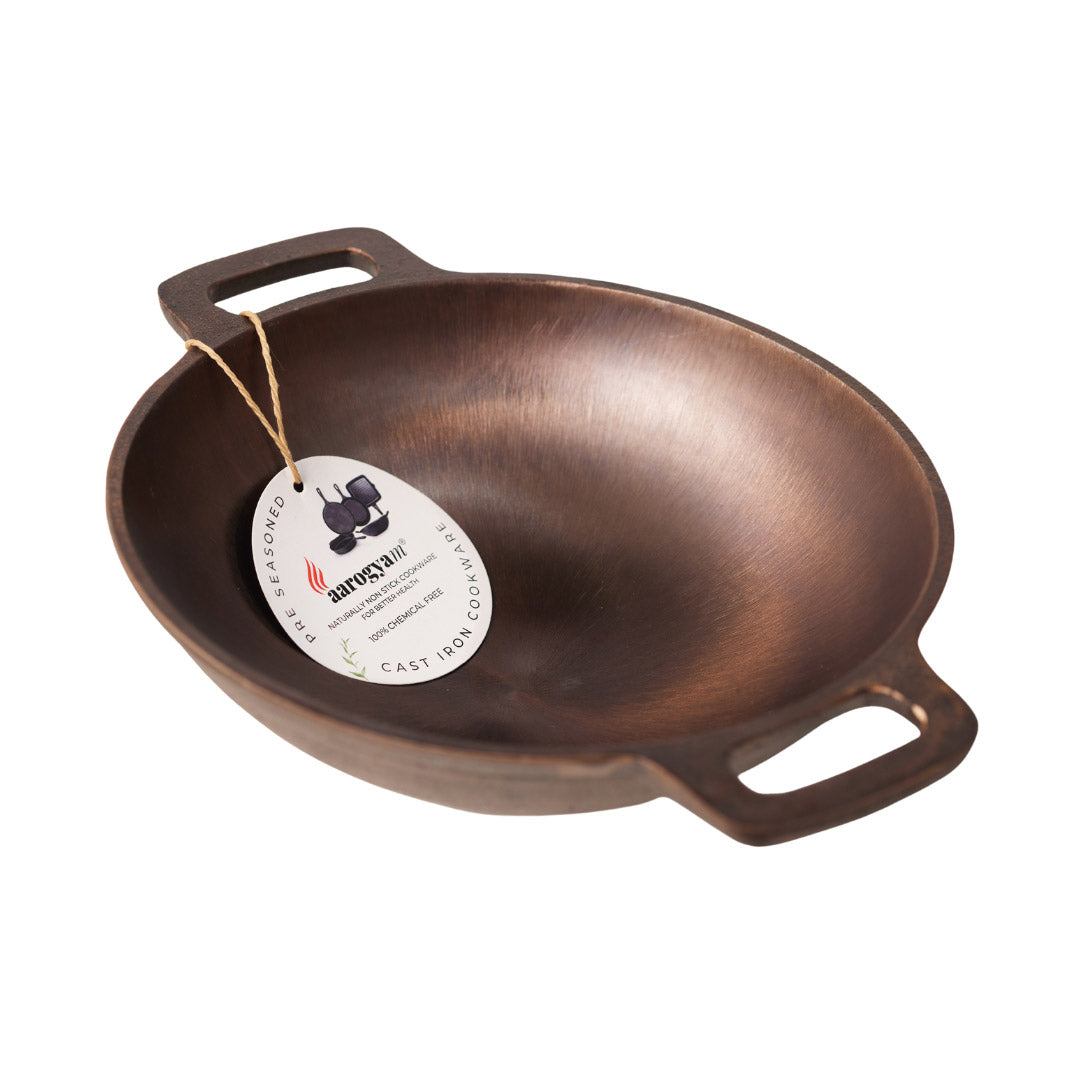 Bronze cast iron wok with a brand tag on a white background
