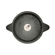 Black cast iron skillet with a brand label on a white background