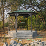 Gazebo in a forested area with 'Aarogyam Energy Devices' sign.