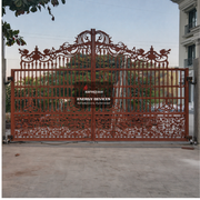 Decorative metal gate with intricate designs in front of a building.
