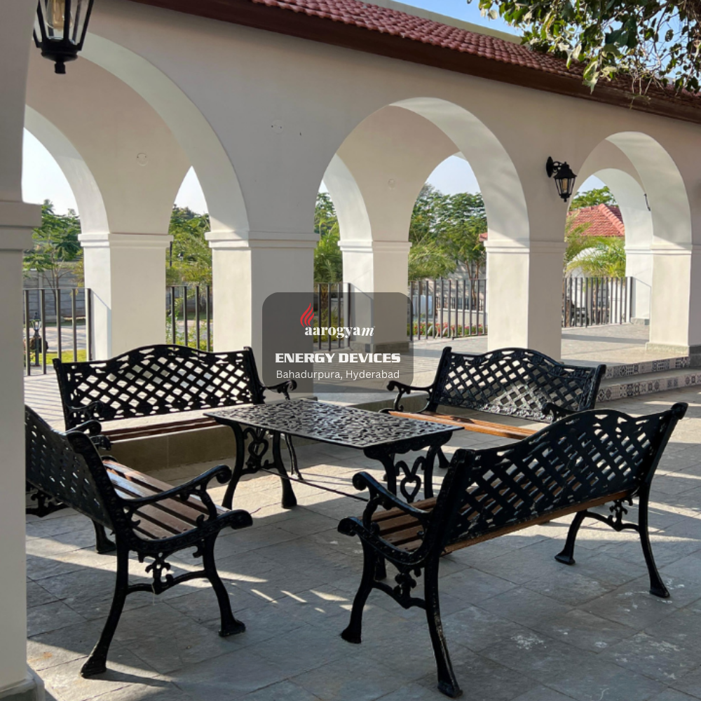 Outdoor patio set with black metal furniture under a covered area.