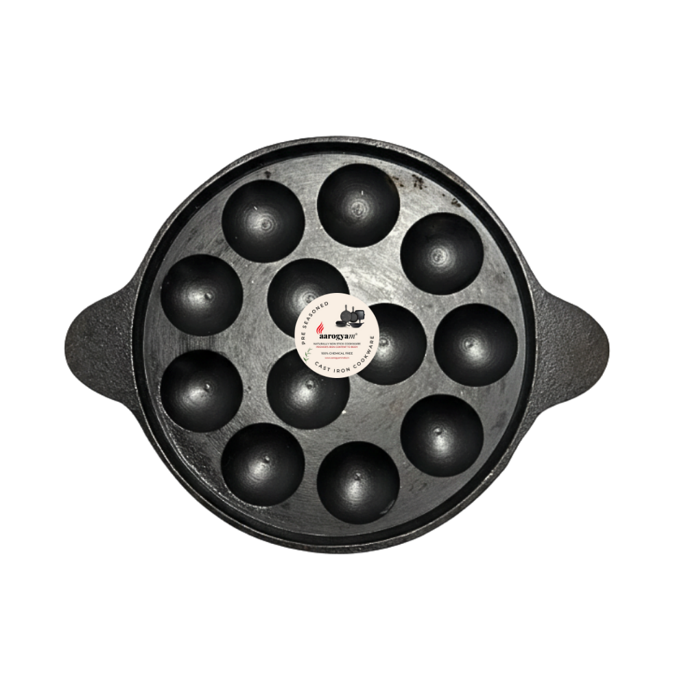 Black cast iron pan with round compartments on a white background