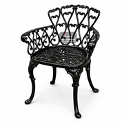 Black metal garden bench with intricate designs on a white background