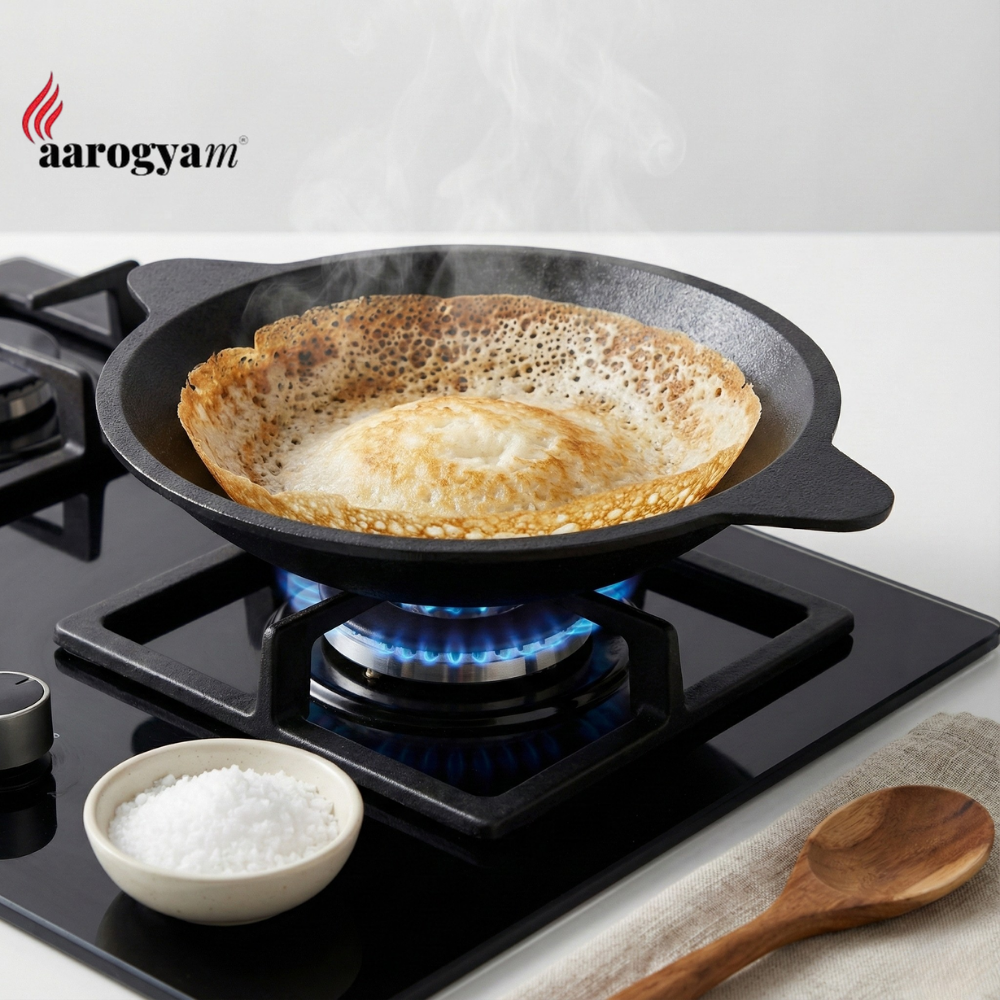 Frying pan with a pancake on a gas stove, featuring the aarogya brand.
