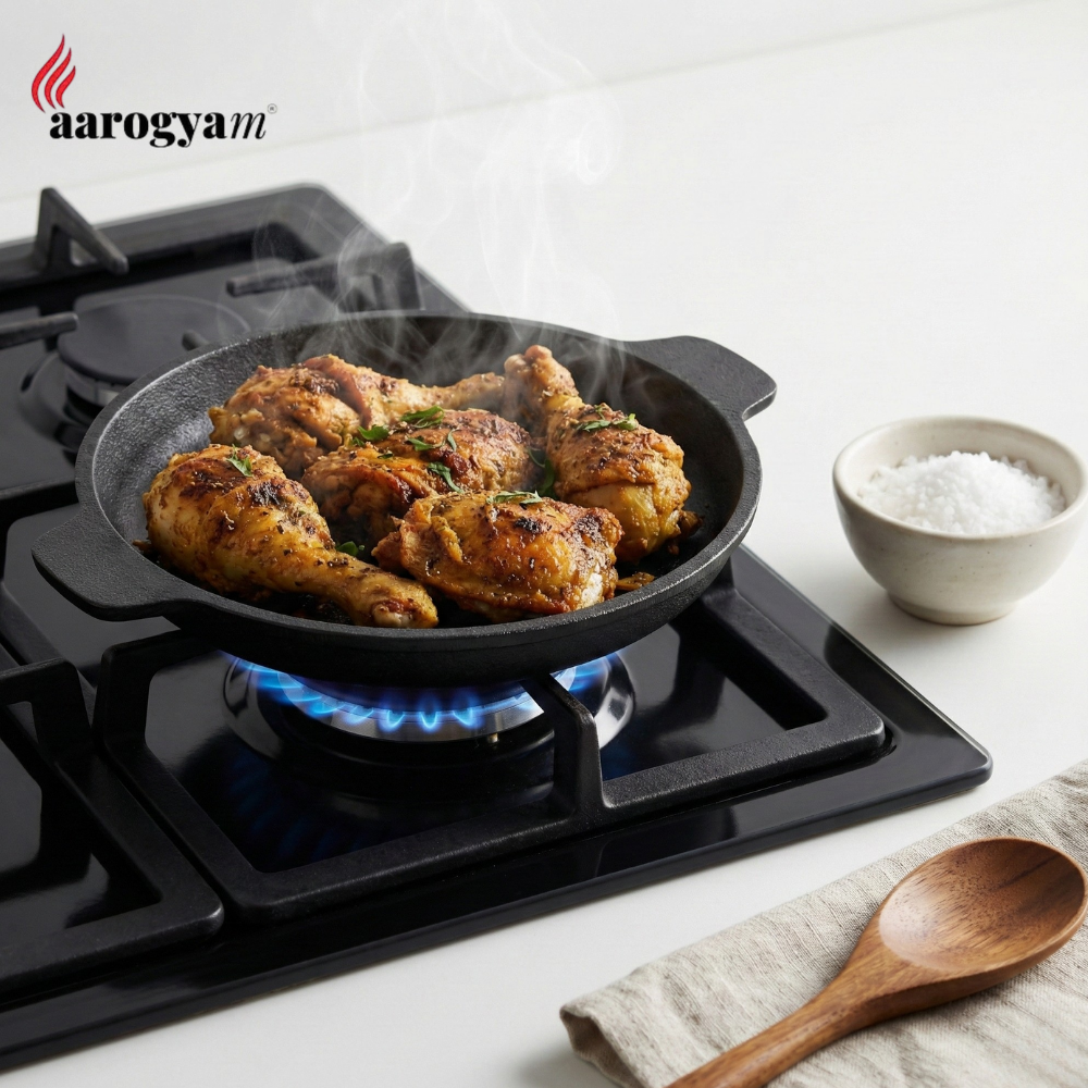 Chicken being cooked in a pan on a gas stove with a bowl of salt and wooden spoon on the side, featuring the Aarogya brand.