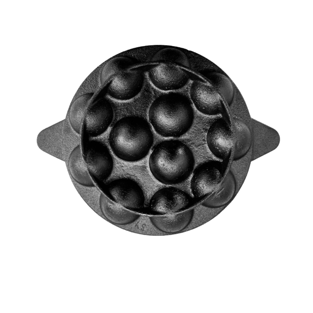 Black metal mold with circular indentations on a white background