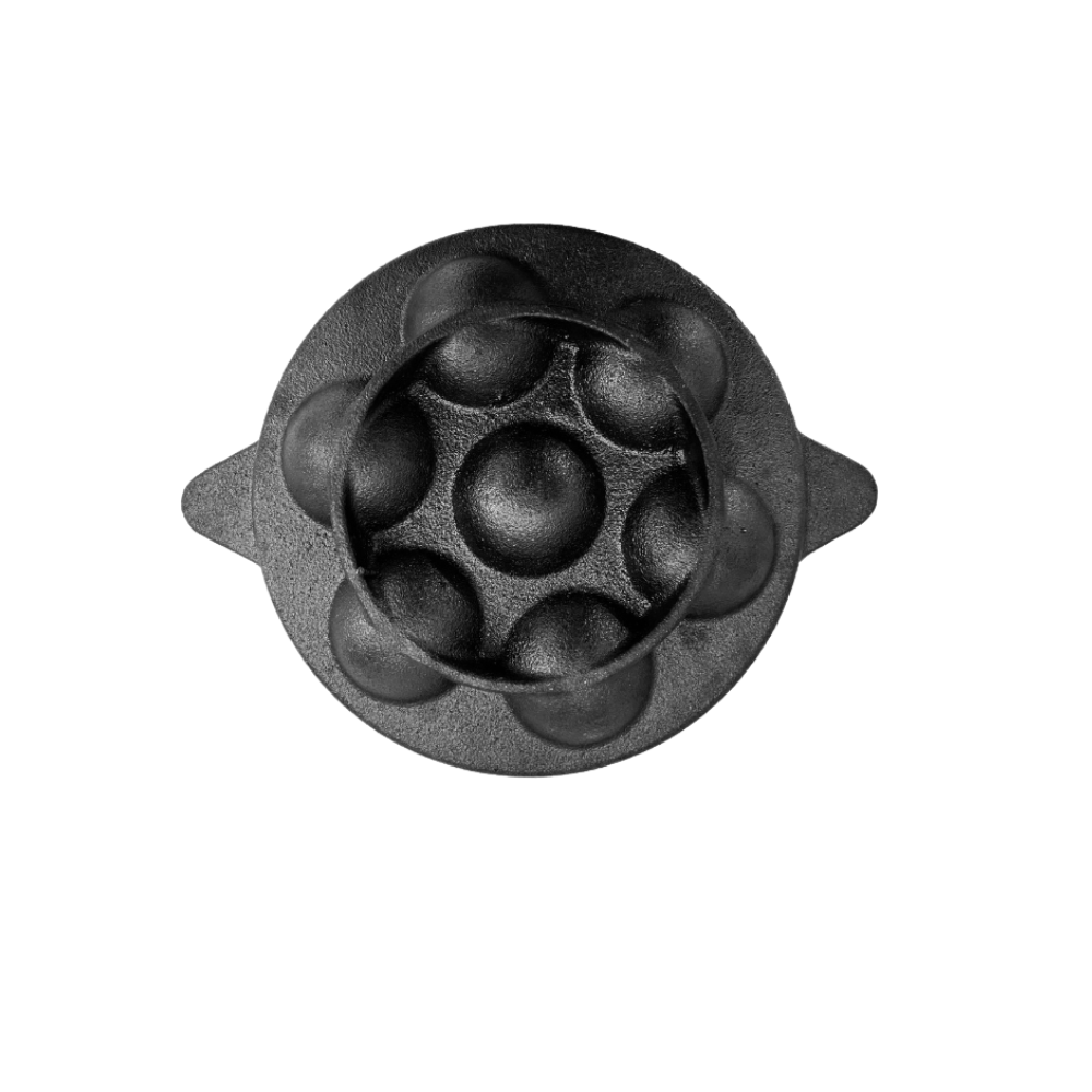 Black metal mold with spherical cavities on a white background
