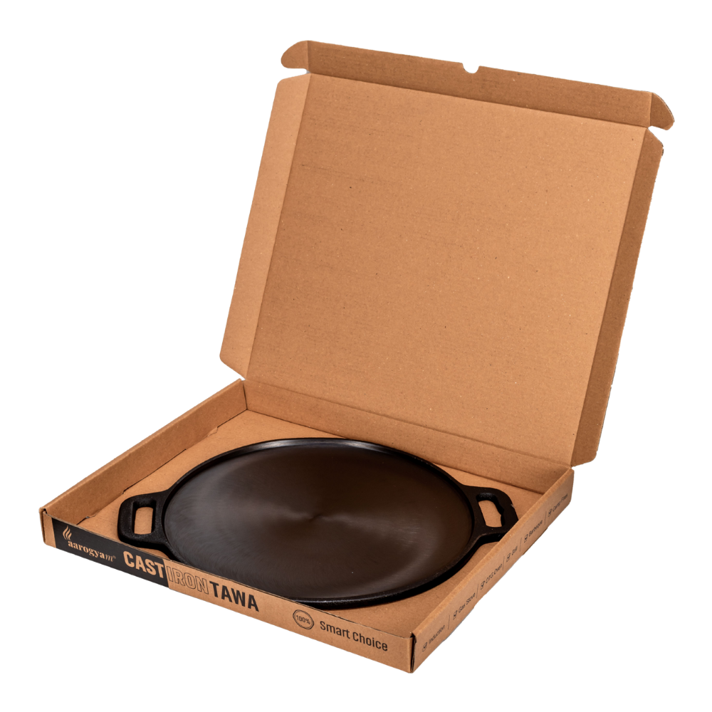 Cast iron tawa in a cardboard box on a white background