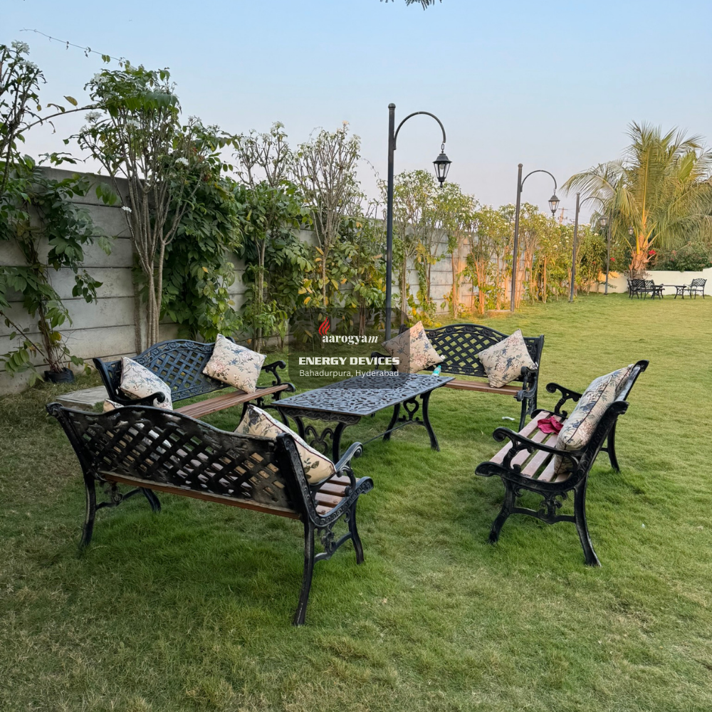 Garden furniture set with chairs and a table on a grassy area, featuring 'Aarogyam Energy Devices' branding.