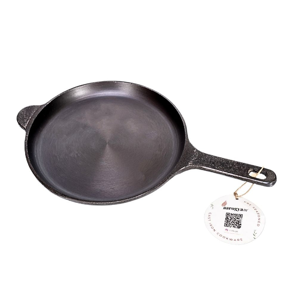 Black cast iron skillet on a white background with a brand tag attached.