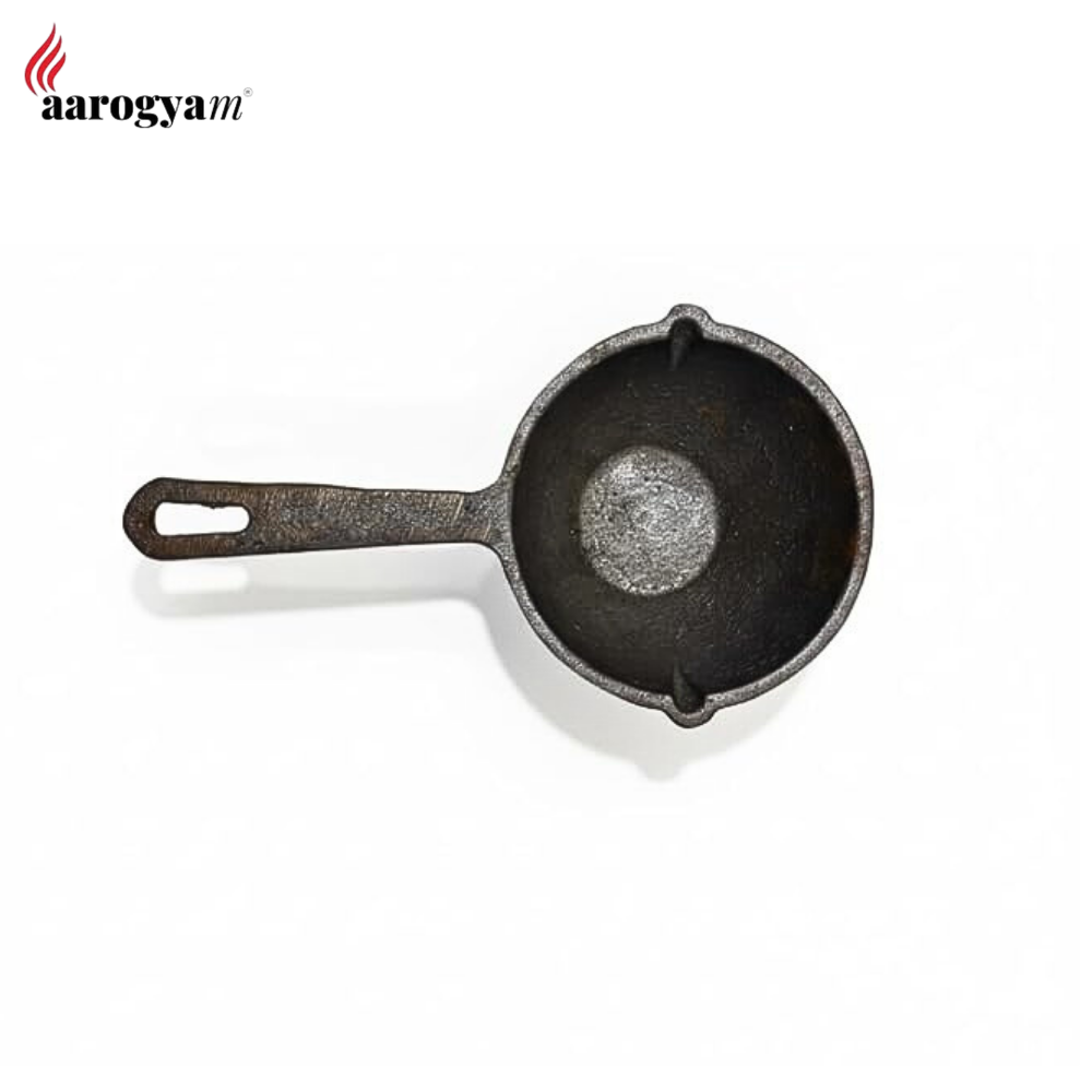 Small black cast iron skillet on a white background with 'aarogya' branding.