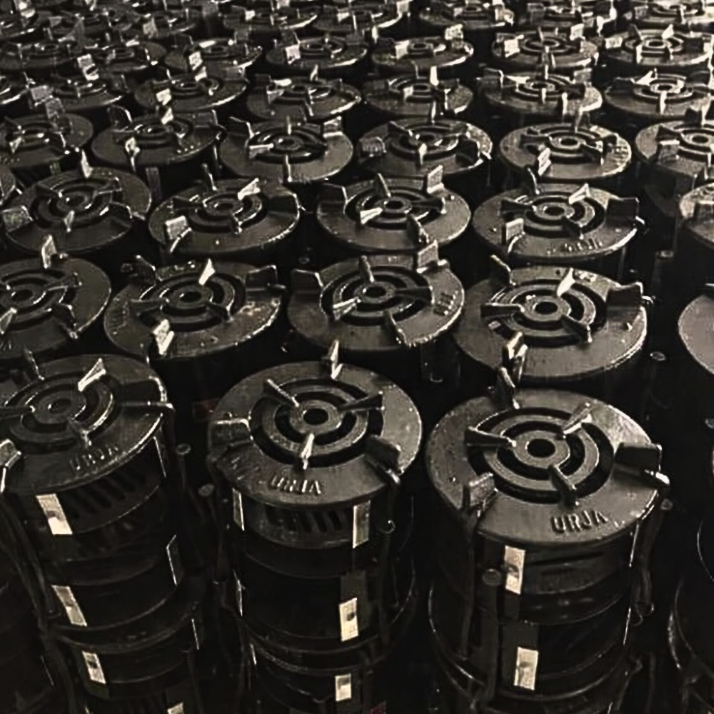 Stacks of black metal parts with central holes and star-shaped patterns.