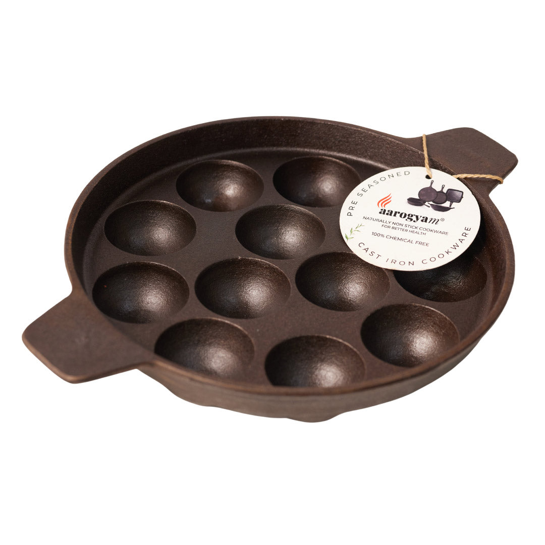 Brown cast iron cast iron appam patra pan with multiple round compartments on a white background