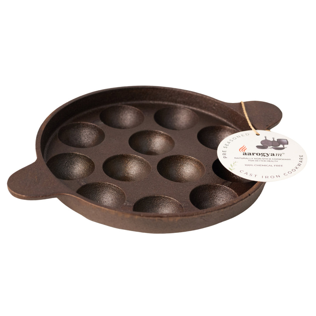 Cast iron mold with multiple round cavities on a white background, featuring a brand tag.