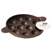 Cast iron mold with multiple round cavities on a white background, featuring a brand tag.