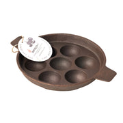 Brown cast iron mold with six round cavities on a white background