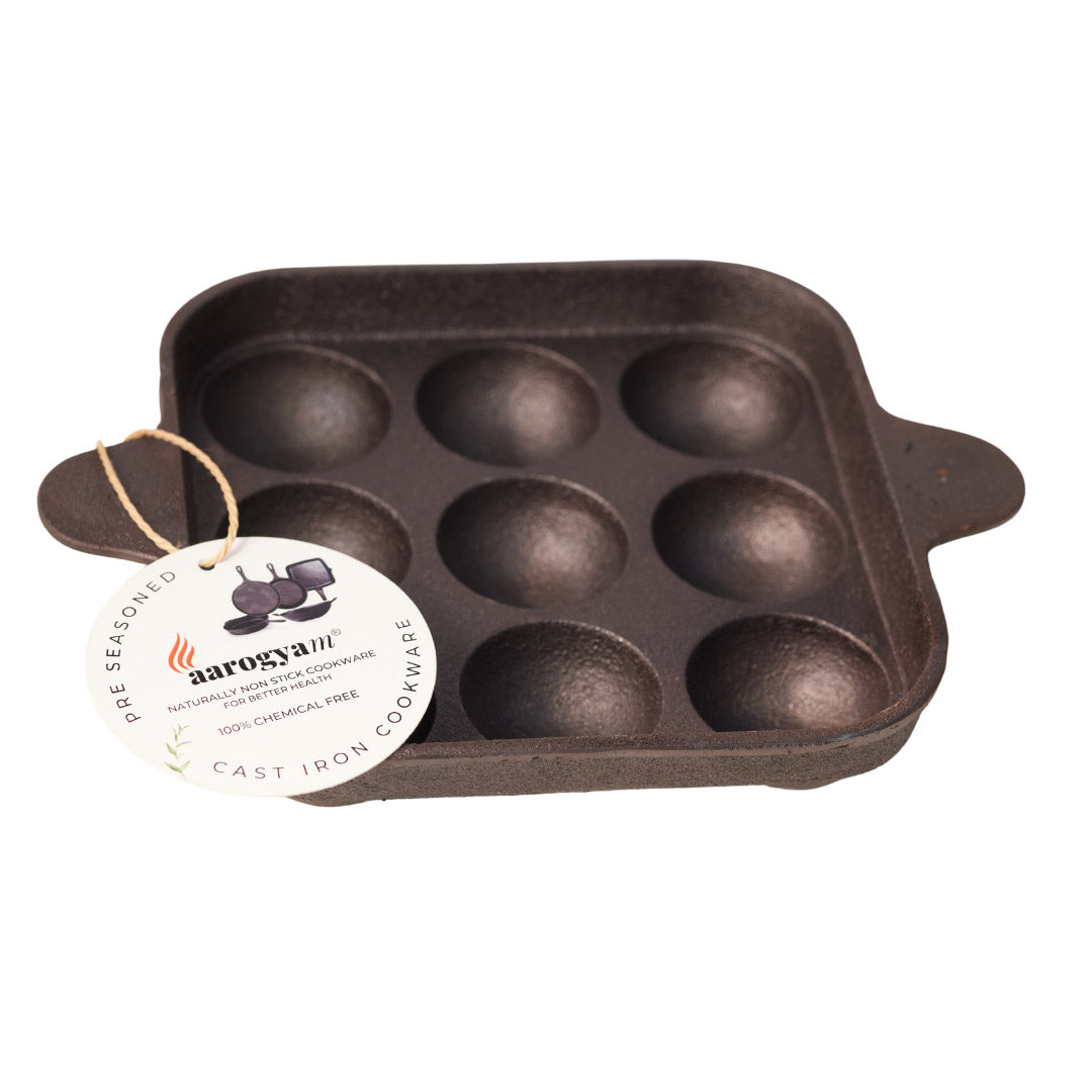 Cast iron muffin pan with aarogyam tag on a white background