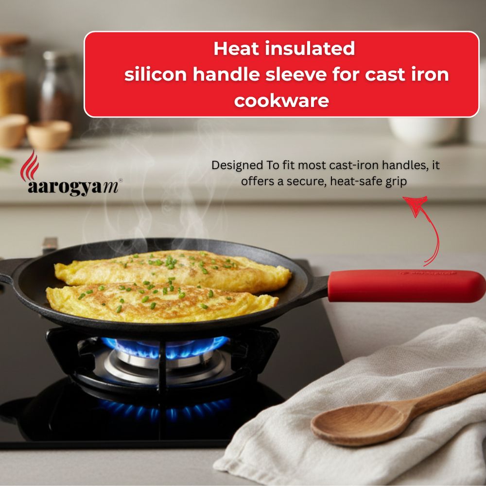 Cast iron skillet with a red heat-insulated handle sleeve on a stove, with 'aarogya' branding.
