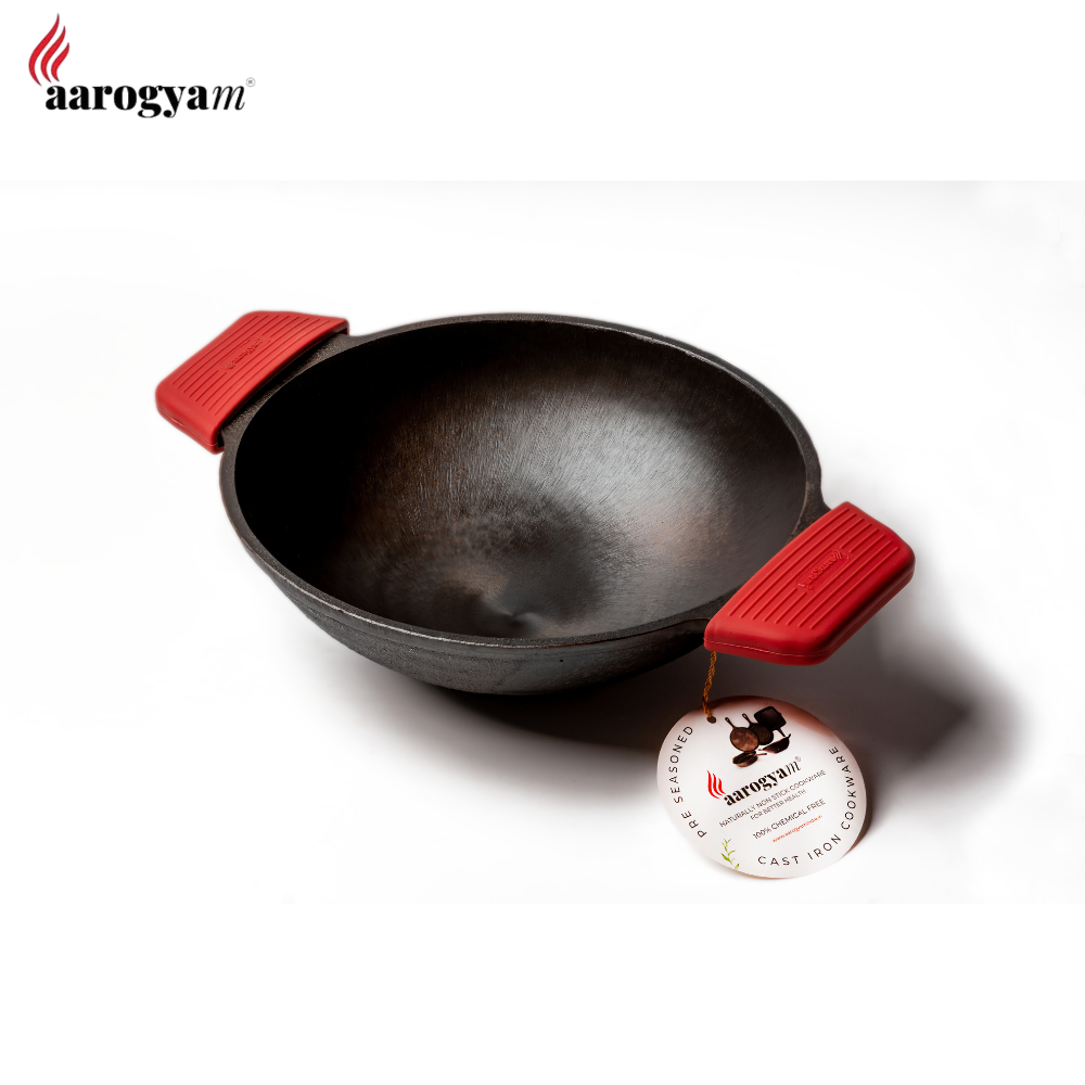 Black wok with red handles on a white background, featuring the aarogyam brand.