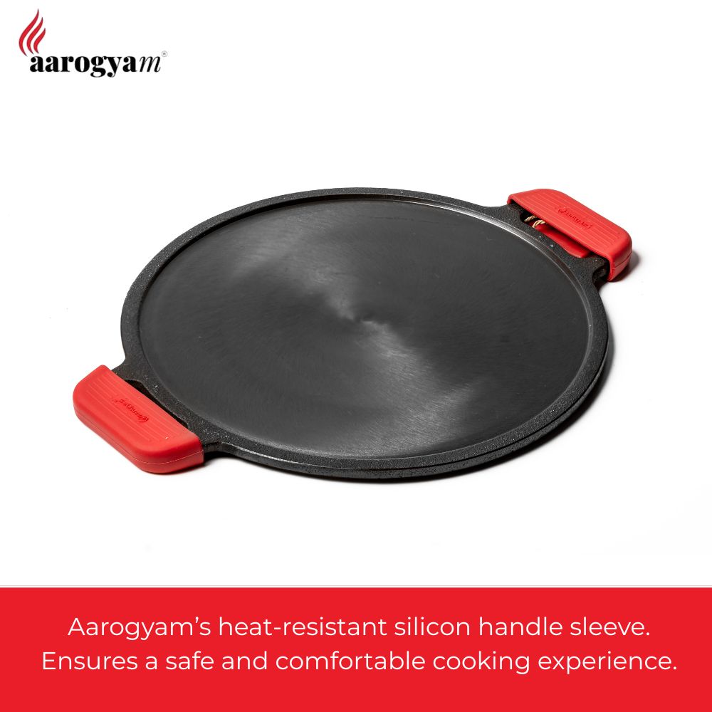 Black pan with red handles on a white background, featuring Aarogyam brand.