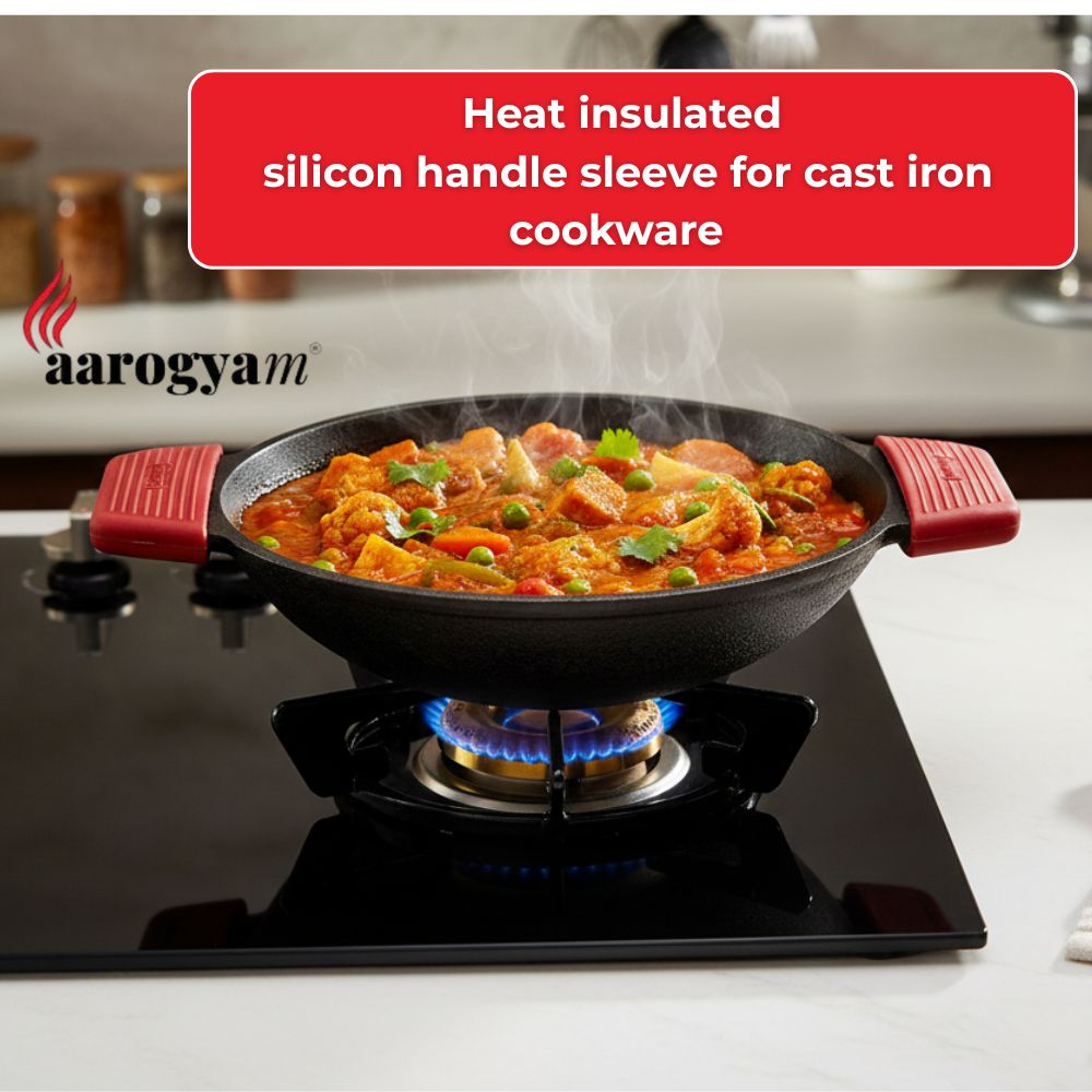 Aarogyam cast iron cookware with red insulated handles on a stove