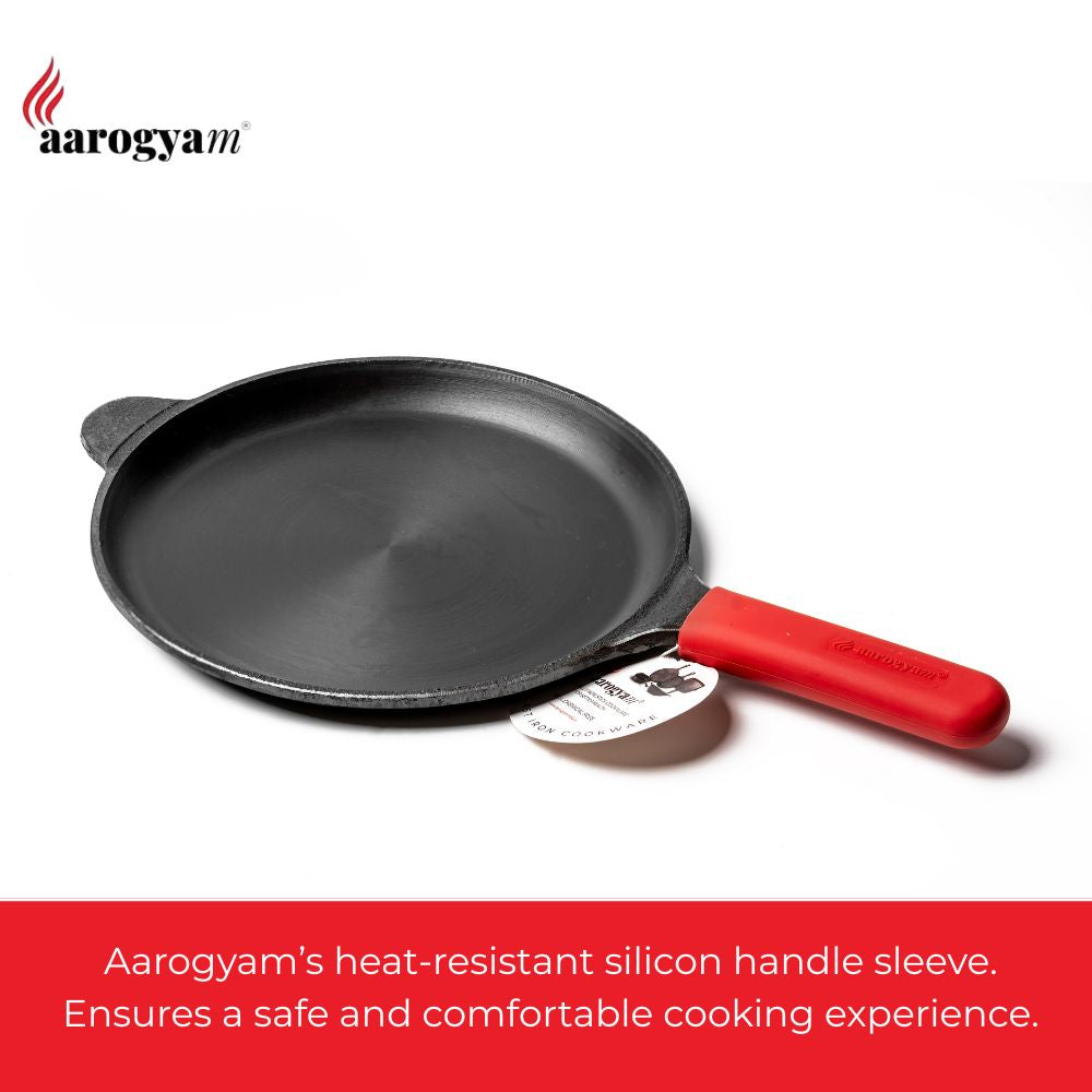 Black frying pan with a red handle featuring a heat-resistant silicon sleeve on a white background.