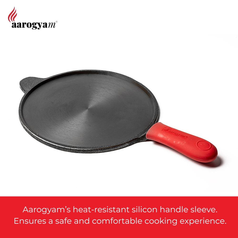 Black frying pan with a red handle on a white background, featuring Aarogyaam branding.