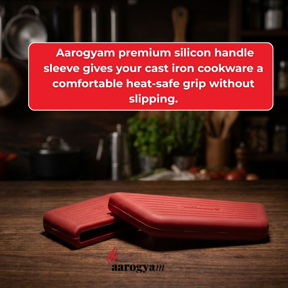 Red silicone handle sleeve for cast iron cookware on a wooden surface with Aarogya brand logo.