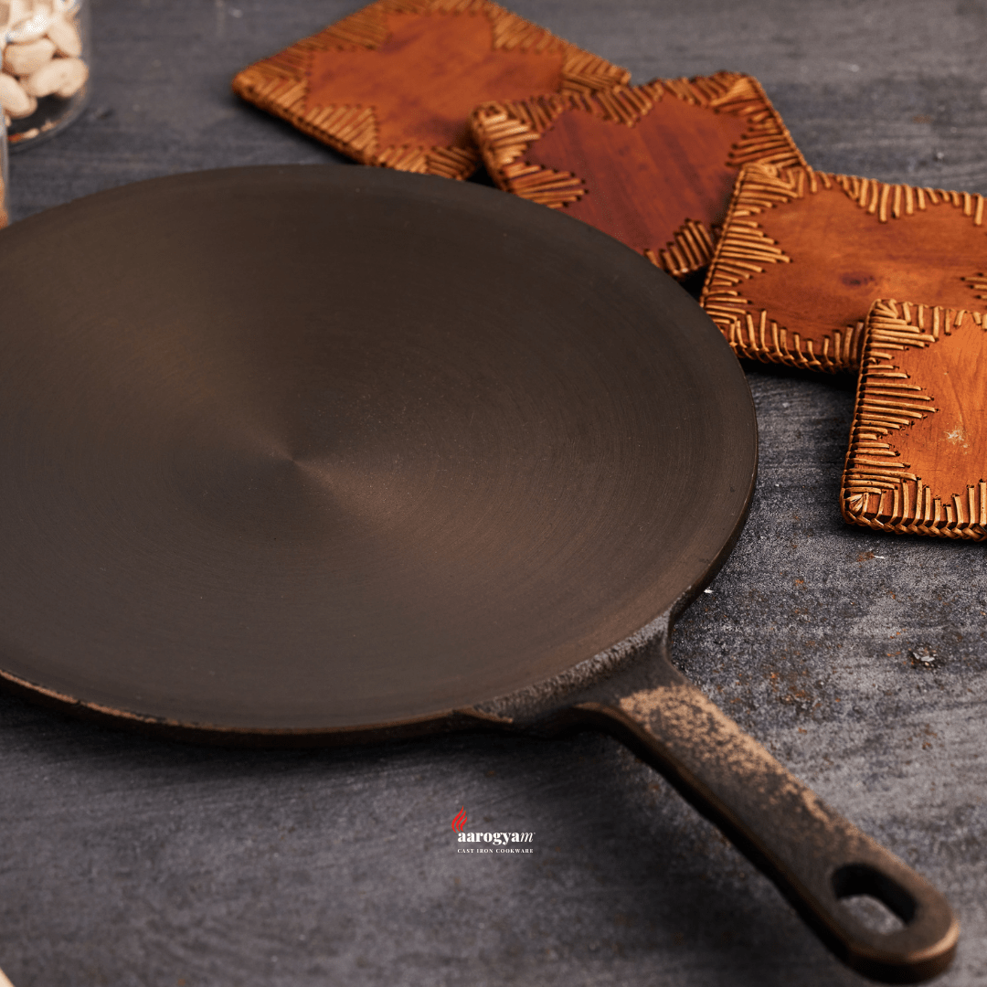 Cast iron skillet on a dark surface with wooden coasters in the background