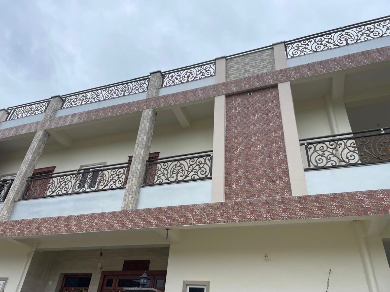 Two-story building with decorative railings on a cloudy day
