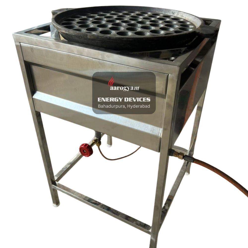 Stainless steel flatbread cooker with multiple holes on a white background, branded 'Aarogyan Energy Devices'.
