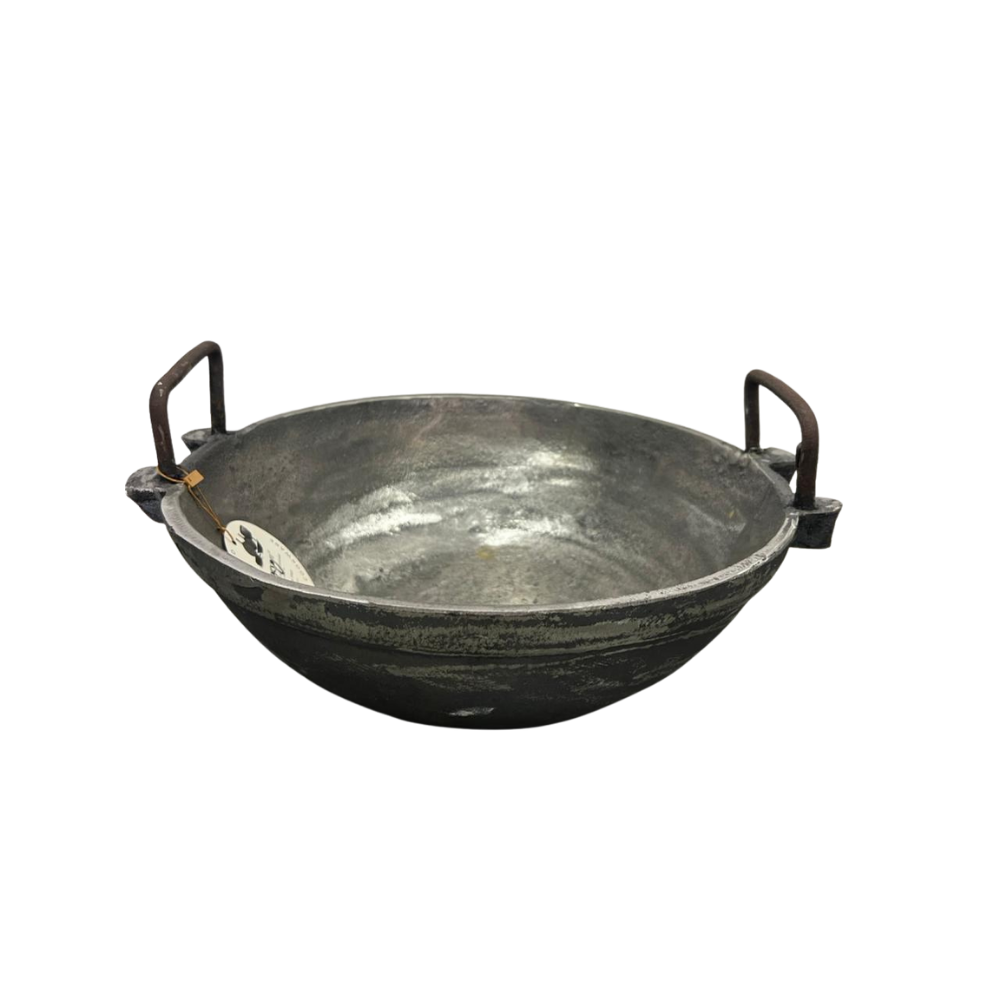 Large metal wok with handles on a white background