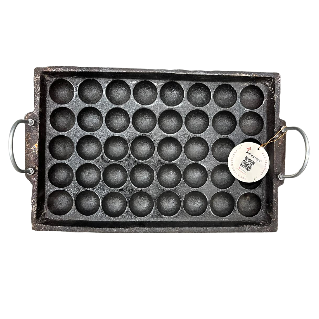 Cast iron mold with round cavities on a white background